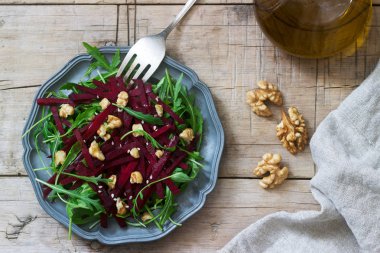 Vitamini salata ham şeker pancarı, roka, ceviz ve zeytin yağı ahşap bir masa üzerinde. Rustik tarzı.
