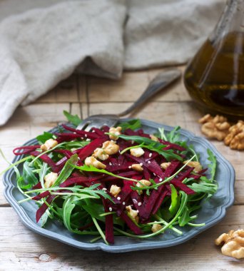 Vitamini salata ham şeker pancarı, roka, ceviz ve zeytin yağı ahşap bir masa üzerinde. Rustik tarzı.