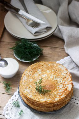 Karabuğday krep ekşi krema ve ahşap bir masa üzerine dereotu ile devam eder. Rustik tarzı.