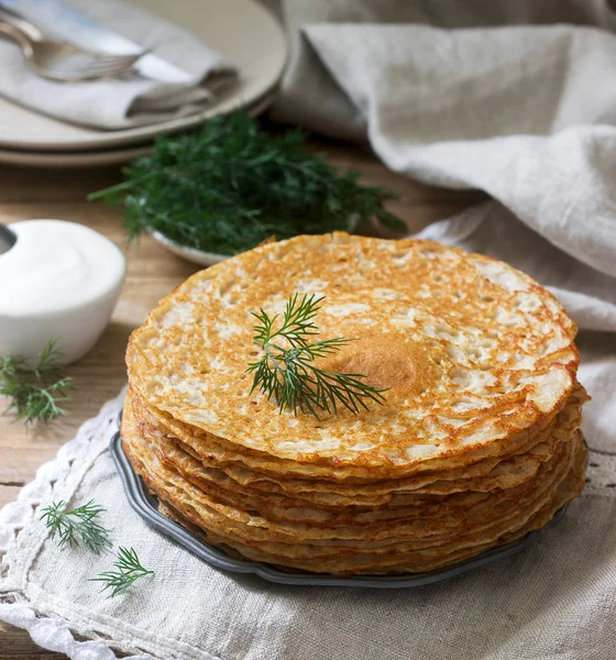 Buchweizen-Pfannkuchen mit saurer Sahne und Dill auf einem Holztisch serviert. rustikaler Stil. — Stockfoto