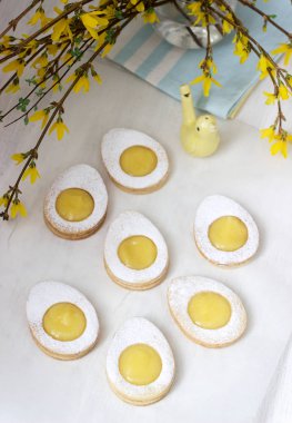 Ev yapımı Paskalya limon çerezler ve hafif bir arka plan üzerinde dallar çiçek açan hor çiçeği.