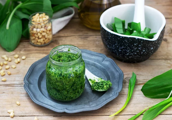 Ramson pesto and ingredients for cooking it on a wooden table. Rustic style. — Stock Photo, Image