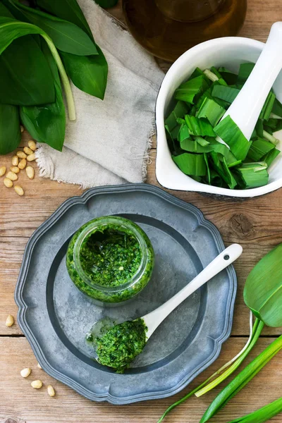 Ramson pesto and ingredients for cooking it on a wooden table. Rustic style. — Stock Photo, Image