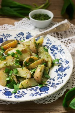 Vejetaryen patates salatası ahşap arka plan üzerinde yabani sarımsak ve pesto sos ile. Rustik tarzı.