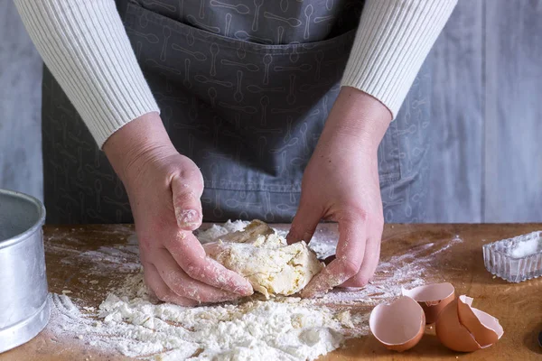Una mujer hace fideos caseros con harina, huevos y sal. Estilo rústico . — Foto de Stock