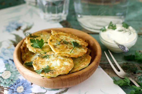 Pancakes with zucchini and sweet corn, served with sour cream, parsley and dill. Vegetarian food. — Stock Photo, Image