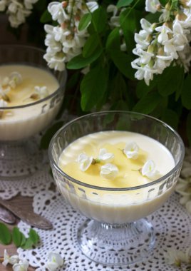 Panna cotta robinia lezzet ile, bal ve beyaz Robinia çiçekleri ile servis edilir. Rustik stil.
