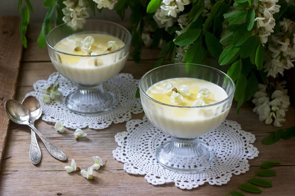 Panna cotta mit Robiniengeschmack, serviert mit Honig und weißen Robinienblüten. rustikaler Stil. — Stockfoto