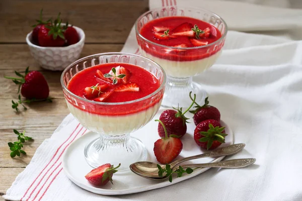 Panna cotta avec sauce aux fraises et tranches de fraises, décorées avec des feuilles de thym. Style rustique . — Photo