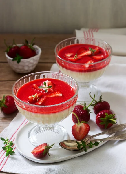 Panna cotta with strawberry sauce and strawberry slices, decorated with thyme leaves. Rustic style. — Stock Photo, Image