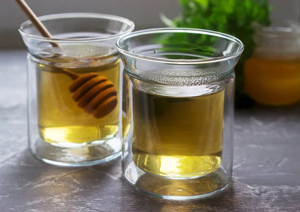 Kruidenthee gemaakt van mint en Citroenmelisse met honing in glazen bekers. Rustieke stijl. — Stockfoto