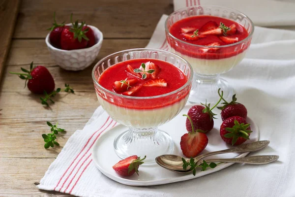Panna cotta avec sauce aux fraises et tranches de fraises, décorées avec des feuilles de thym. Style rustique . — Photo