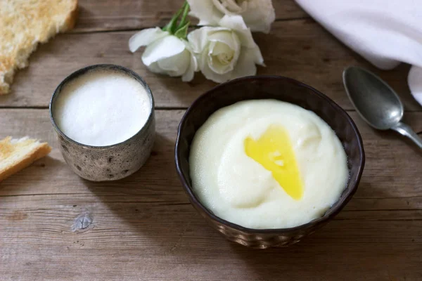 Hemlagad frukost med manna gryn gröt, kaffe med mjölk och rostat bröd på en trä bakgrund. Rustik stil. — Stockfoto