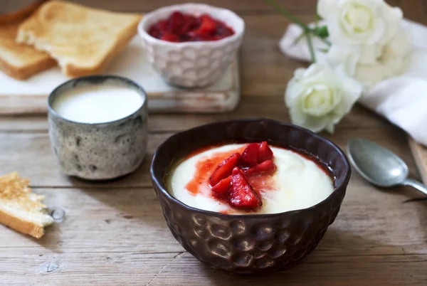 Hausgemachtes Frühstück mit Grießbrei, Erdbeersoße, Kaffee mit Milch und Toast auf einem hölzernen Hintergrund. — Stockfoto