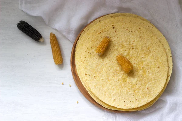木板和玉米棒上的一叠圆形玉米玉米饼. — 图库照片