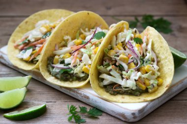 Vejetaryen tacos ahşap bir arka plan üzerinde lahana salatası ile doldurulmuş. Rustik stil.