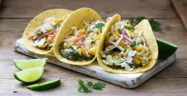 Vejetaryen tacos ahşap bir arka plan üzerinde lahana salatası ile doldurulmuş. Rustik stil.