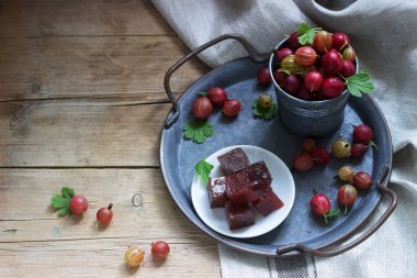 Bir teneke tepsi üzerinde Bektaşi üzümü marmelat küpleri ve Bektaşi üzümü. Rustik tarzı.