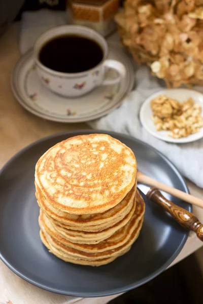 Pancakes with banana, nuts and honey, served with tea. Rustic style. — Stock Photo, Image