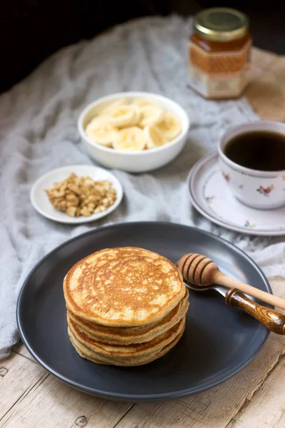 Panquecas com banana, nozes e mel, servidas com chá. Estilo rústico. — Fotografia de Stock