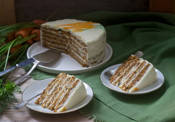 Carrot cake, pieces of cake with curd cream and carrots on a wooden background. Rustic style. — Stock Photo, Image