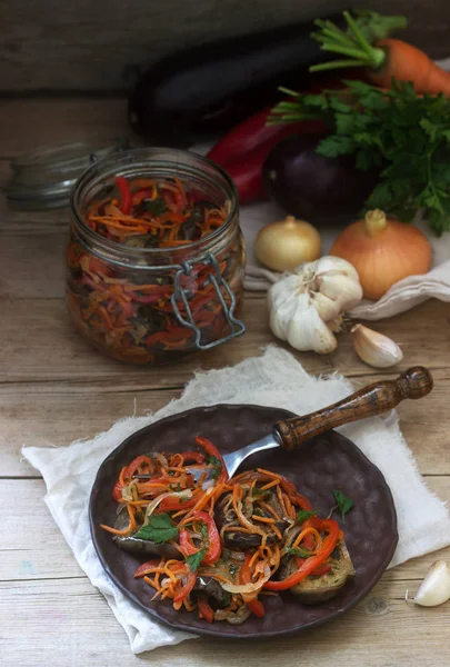 Овощной салат из баклажанов, сладкого перца, моркови и лука и овощей для салата на деревянном фоне . — стоковое фото
