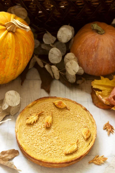 Bolo caseiro tradicional de abóbora americana, decorado com biscoitos em um fundo de abóboras e folhas de outono . — Fotografia de Stock