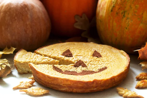 Torta casera tradicional de calabaza americana decorada con cacao sobre un fondo de calabazas y hojas de otoño . — Foto de Stock