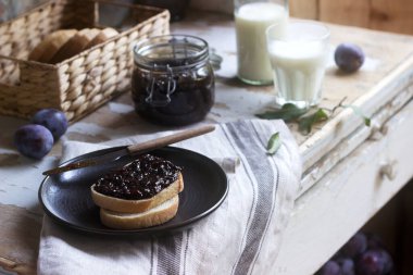 Erik reçelli ekmek tostu, ahşap bir zeminde süt ve erikle servis edilir. Kırsal biçim.