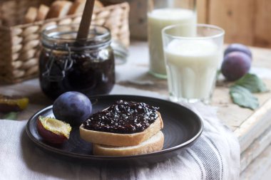 Erik reçelli ekmek tostu, ahşap bir zeminde süt ve erikle servis edilir. Kırsal biçim.