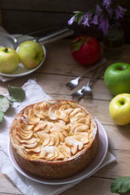 Elma kremalı turta, ahşap arka planda elmalar ve tabaklar. Kırsal biçim.