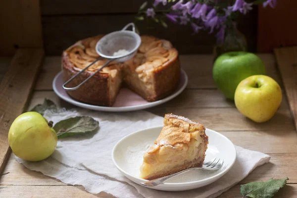 Пирог с начинкой из яблочного крема, яблоки и блюда на деревянном фоне. Сельский стиль . — стоковое фото