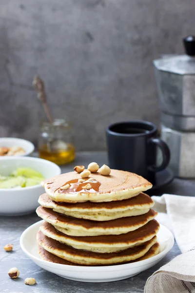 Vegetarian breakfast of pancakes, coffee, honey, nuts and fruits. — Stock Photo, Image