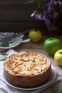 Elma kremalı turta, ahşap arka planda elmalar ve tabaklar. Kırsal biçim, seçici odak.