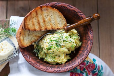 Geleneksel Moldova ya da Romanya usulü peynirli omlet, ahşap bir yüzey üzerinde ekmekle servis ediliyor. Kırsal biçim.