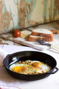 Fırında yumurta, soğan ve baharatlı, dökme demir tavada. Seçici odak.