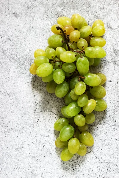 Bärnsten bunt druvor på en grå betong bakgrund. — Stockfoto