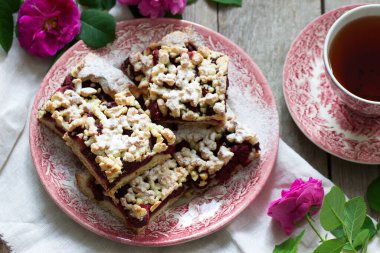 Kiraz arenalı tatlı pasta ve ahşap arka planda streusel. Kırsal biçim, seçici odak.
