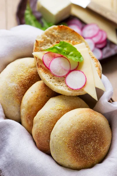 English muffins from whole grain and flax meal, filed with cheese and radish. Rustic style, selective focus.