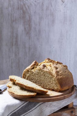 Ev yapımı İrlanda sodası ekmeği parçalara ayrılmış ve tahta zemin üzerinde bıçak var. Kırsal biçim, seçici odak.