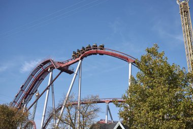 Kopenhag, Danimarka - 09 Ekim 2018 : Tivoli bahçesinde Rutschebanen lunapark treni ve Vertigo cazibe görünümü