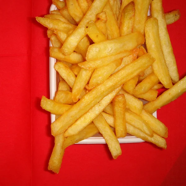 Pommes frites på rött bord — Stockfoto