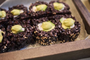 Milano, İtalya - 17 Aralık 2017 : Avokado ve karidesli siyah pirinç ruloları