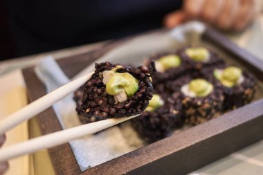 Milano, İtalya - 17 Aralık 2017 : Avokado ve karidesli siyah pirinç ruloları