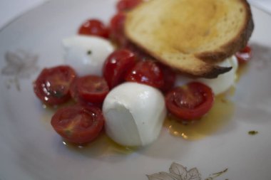 Mozzarella peynirli Caprese, taze vişneli domates ve kızarmış ekmek.