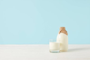 süt cam ve mavi renkli kağıda sarılı şişe süt 