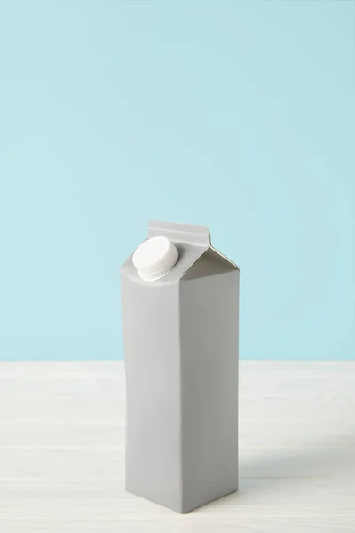 milk in blank carton package on blue background