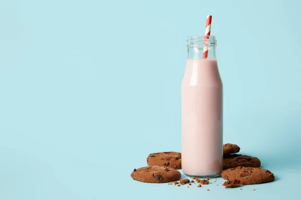 Schokoladenkekse Und Milchshake Flasche Mit Trinkhalm Auf Blauem Hintergrund — Stockfoto