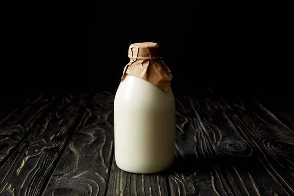 Verse Melk Fles Verpakt Door Papier Zwarte Achtergrond — Stockfoto