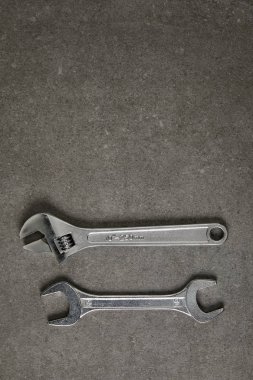 top view of adjustable wrench and spanner on gray surface  clipart